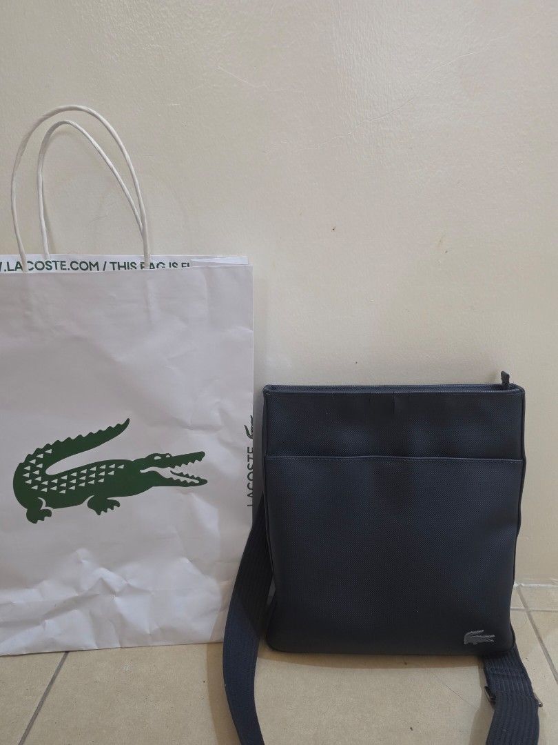 Lacoste Crossbody Bag Authentic with Paper Bag (Category: Cross-body Bags) located in Valenzuela. Submitted by ashagreenpink (Listing ID 1438749293, Image 2). Description: - Lacoste crossbody bag - bLue Dark color - Front pocket - Zipper closure - Adjustable strap - Main compartment - Inner pocket - Includes Lacoste paper bag - my crack sa harap pero d nmn halata. -in good condition Gcash Mop ng item LBC or lalamove.