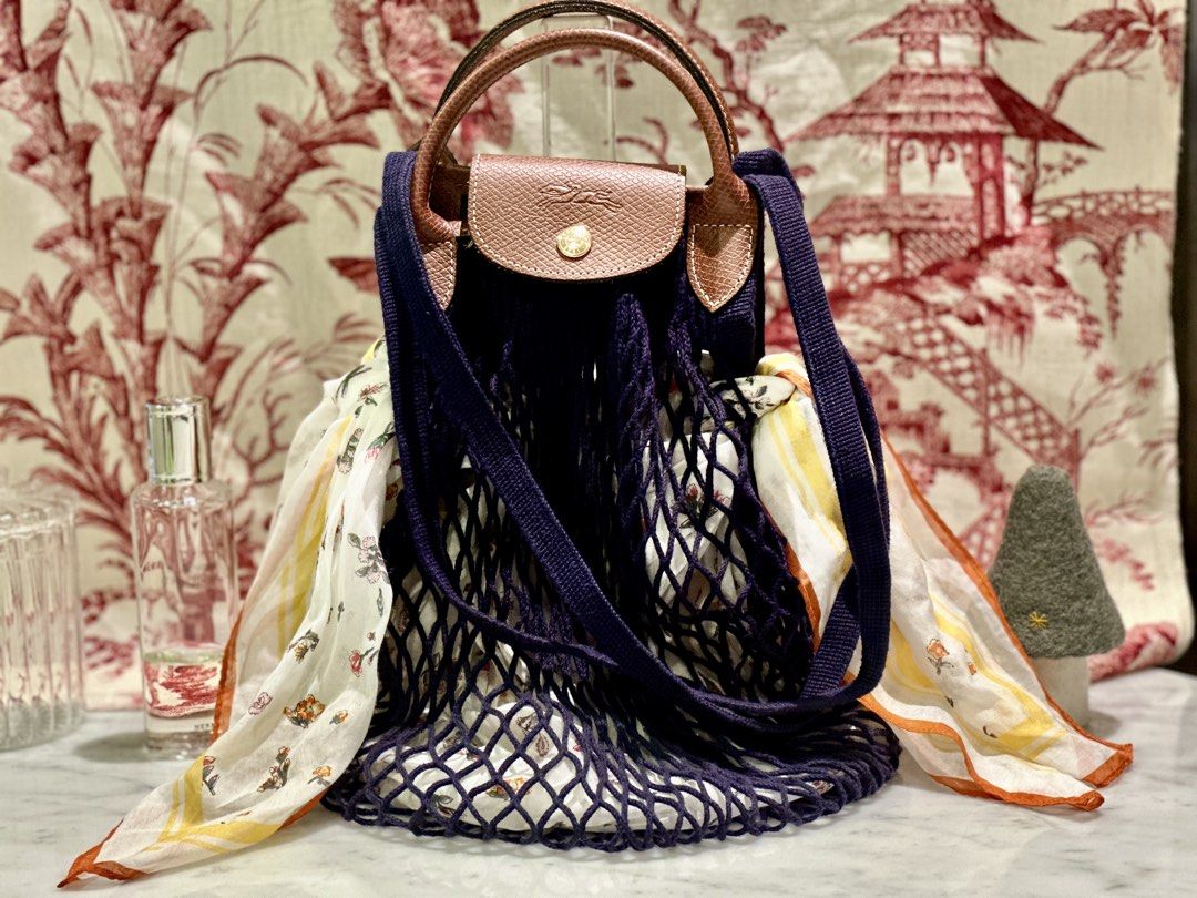 Longchamp Le Pliage Handbag with Net Bag (Category: Luxury Bags & Wallets) located in Manila. Submitted by gravitykicks (Listing ID 1438767850, Image 1). Description: - Longchamp Le Pliage handbag - Brown leather handle - Navy blue strap - Includes navy net bag - Features a colorful scarf.