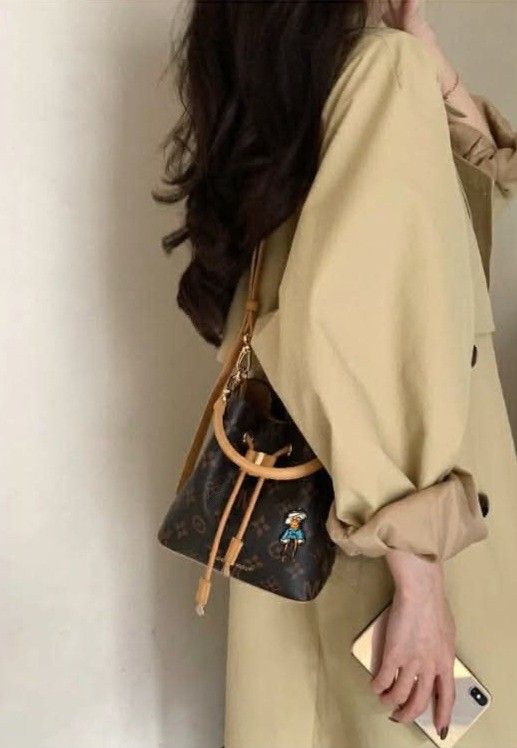 Mini Bucket Bag with Cartoon Patch (Category: Luxury Bags & Wallets) located in Cabanatuan. Submitted by almaespino24263 (Listing ID 1438861778, Image 1). Description: - Mini bucket bag - Brown monogram pattern - Drawstring closure - Tan strap - Cartoon patch - Leather-like material - Stylish and compact - Ideal for everyday use.