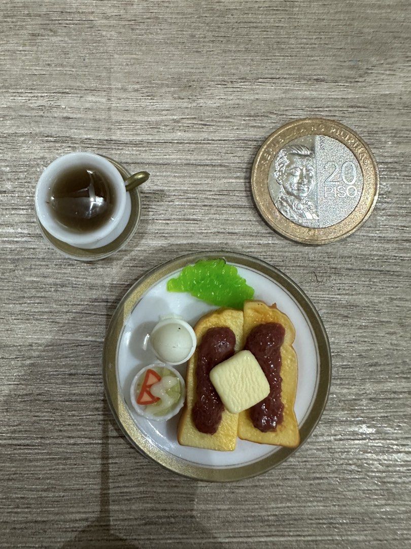 Miniature Breakfast Set (Category: Coffee & Tea Tableware) located in Muntinlupa City. Submitted by camotepie (Listing ID 1438819542, Image 1). Description: - Adorable miniature breakfast set. - Includes: plate with toast, jam, butter, egg, pickles, cup of tea, and saucer. - Perfect for dollhouses and miniature collectors. - Detailed and well-crafted..