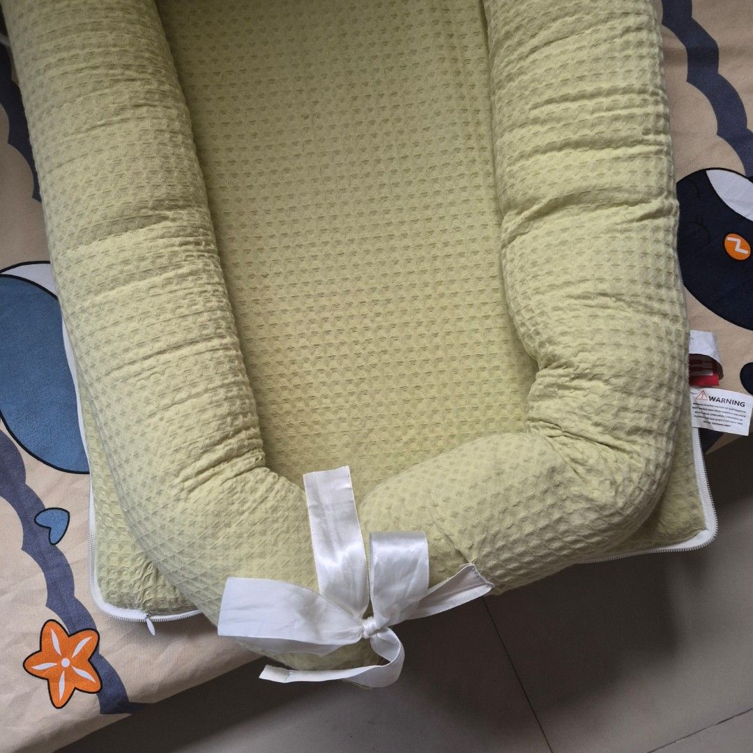 Newborn co-sleeping bed (Category: Cots & Cribs) located in Cavite. Submitted by sydslittlecorner (Listing ID 1438790511, Image 3). Description: • Bought at the orange app for P1,299 • Added pillow fillings to the sides of the bed to make it more firm yet soft • Only used for 1 month ● Good for newborn babies and parents who plan to co-sleep • Dimensions: 99 x 55 x 15.