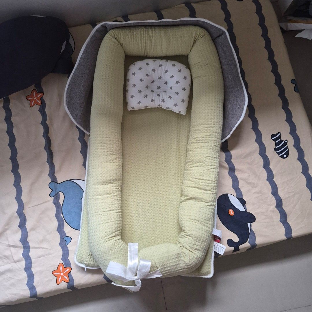 Newborn co-sleeping bed (Category: Cots & Cribs) located in Cavite. Submitted by sydslittlecorner (Listing ID 1438790511, Image 1). Description: • Bought at the orange app for P1,299 • Added pillow fillings to the sides of the bed to make it more firm yet soft • Only used for 1 month ● Good for newborn babies and parents who plan to co-sleep • Dimensions: 99 x 55 x 15.