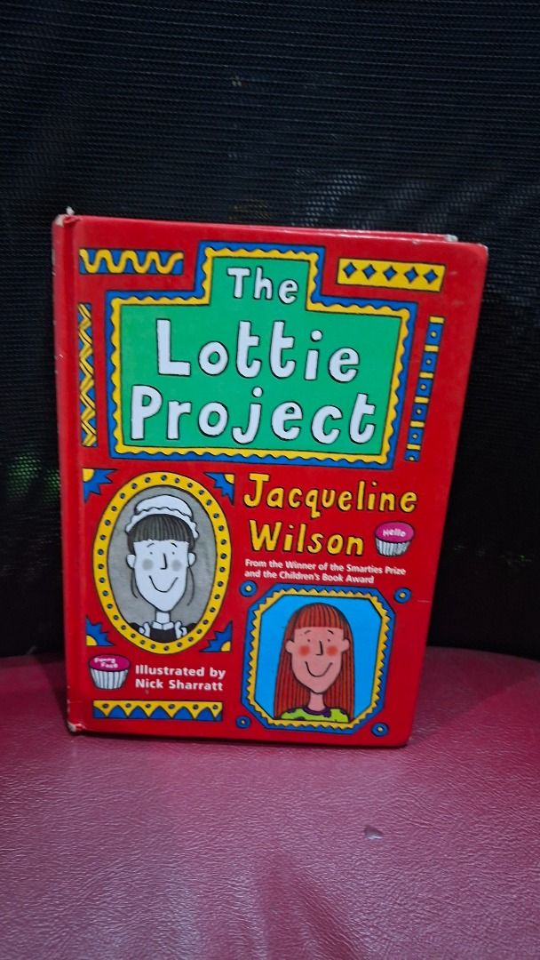 The Lottie Project by Jacqueline Wilson (Category: Children's Books) located in Pasig City. Submitted by loisegems (Listing ID 1438856131, Image 1). Description: - The Lottie Project by Jacqueline Wilson - Illustrated by Nick Sharratt - Hardbound - Features a red cover with colorful illustrations - Author's name is prominently displayed - Spine shows some wear.