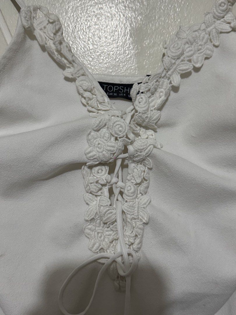 Topshop White Lace-Up Bodysuit (Category: Others Tops) located in Quezon City. Submitted by maxmaximoo (Listing ID 1438878782, Image 2). Description: - Topshop white bodysuit - Lace-up detail - Delicate lace trim - Scoop neckline and spaghetti straps - Size: EUR 36, UK 8, US 4 - Made in Romania - Smooth, solid white fabric.