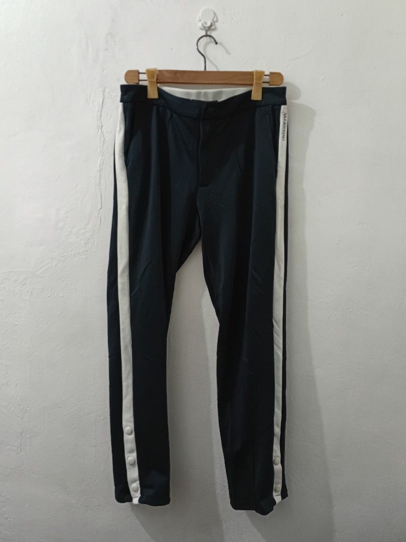 VALENTINO Sweat Trouser Track Pants (Category: Luxury Apparel) located in Navotas City. Submitted by ms.soulana (Listing ID 1438835030, Image 1). Description: PreOwned Lightly Used Authentic Valentino track pants - Color: Navy blue - Size: 48 Waist 32-34" X L39" - Made in Italy - White stripes on sides - Button details on legs - Red and white stripe detail on waistband Sign of Wear Good Condition 8.9/10 .