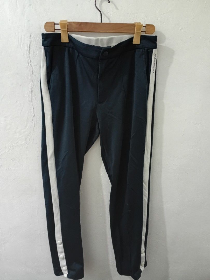 VALENTINO Sweat Trouser Track Pants (Category: Luxury Apparel) located in Navotas City. Submitted by ms.soulana (Listing ID 1438835030, Image 3). Description: PreOwned Lightly Used Authentic Valentino track pants - Color: Navy blue - Size: 48 Waist 32-34" X L39" - Made in Italy - White stripes on sides - Button details on legs - Red and white stripe detail on waistband Sign of Wear Good Condition 8.9/10 .
