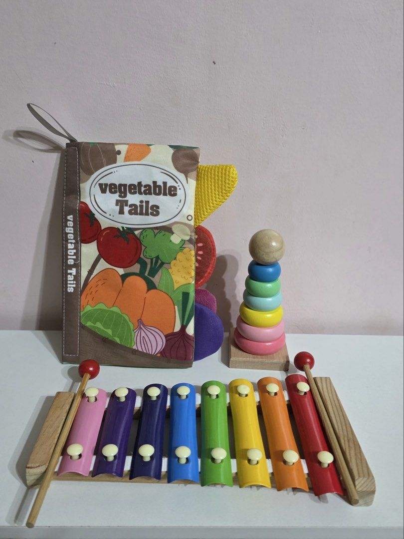 Vegetable Tails Book, Xylophone, and Stacking Toy (Category: Educational & Learning Toys) located in Plaridel. Submitted by chyambee (Listing ID 1438877057, Image 1). Description: - Vegetable Tails fabric book featuring corn, pumpkin, eggplant, tomato, onion, and carrot illustrations. - Rainbow-colored xylophone with two mallets. - Wooden stacking toy with colorful rings. - Perfect for toddlers!.