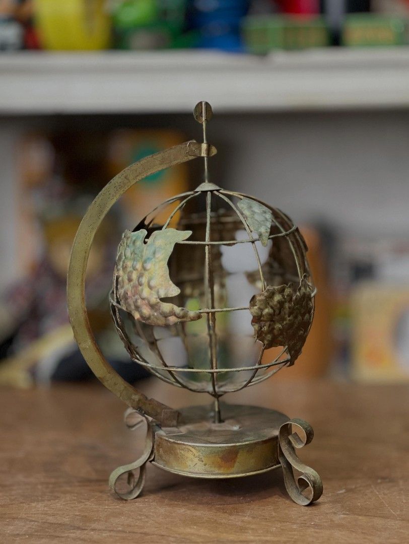 Vintage Metal Globe Ornament (Category: Vintage Collectibles) located in Valenzuela. Submitted by upcycle_things (Listing ID 1438716257, Image 2). Description: - Vintage metal globe ornament - Features a detailed world map - Supported by a metal stand and curved arm - Ideal for desk or shelf decoration - Unique, aged appearance.