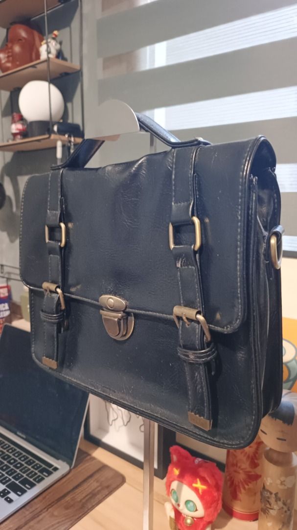Vintage Style Satchel Bag (Category: Luxury Bags & Wallets) located in Manila. Submitted by bag_hobbit (Listing ID 1438794258, Image 2). Description: - Classic satchel design - Vintage aesthetic - Flap closure with metal clasp and buckle straps - Top handle and detachable shoulder strap - Dark color with gold-colored hardware - Made of a leather-like material.