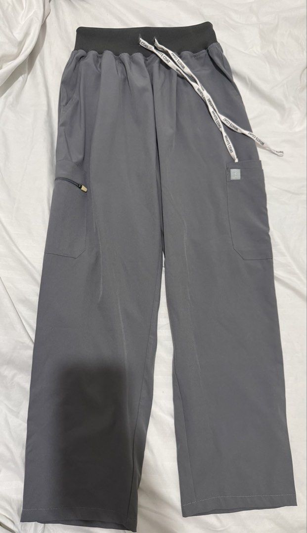 White Coat Gray Scrub Pants (Category: Other Bottoms) located in Manila. Submitted by drewgreig95 (Listing ID 1438854085, Image 1). Description: - White Coat gray scrub pants - Waist: Approximately 30 inches - Length: Approximately 39 inches - Drawstring waistband - Multiple pockets (including a zippered pocket) - Smooth, likely synthetic material - Relaxed fit.