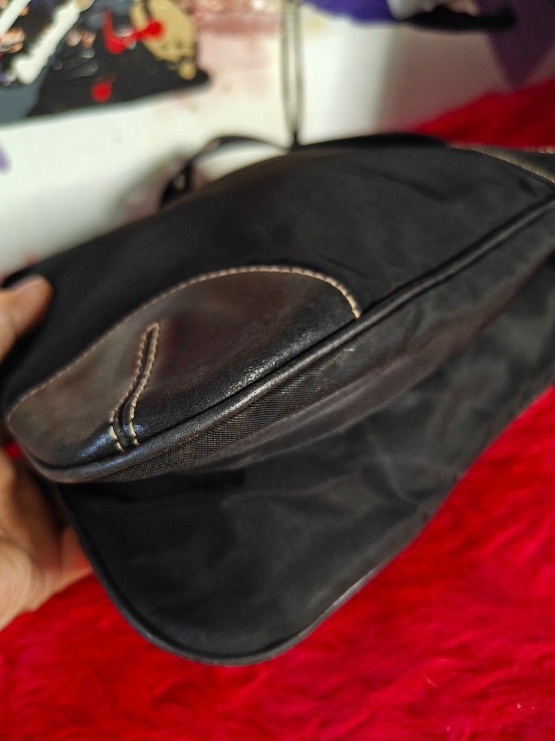Auth Prada sling bag (Category: Luxury Bags & Wallets) located in Las Pinas. Submitted by liezel49 (Listing ID 1435702022, Image 2). Description: Black quilted handbag with a zip closure. Features a chain detail and knotted handles. The bag has a rectangular shape. The bag is black..