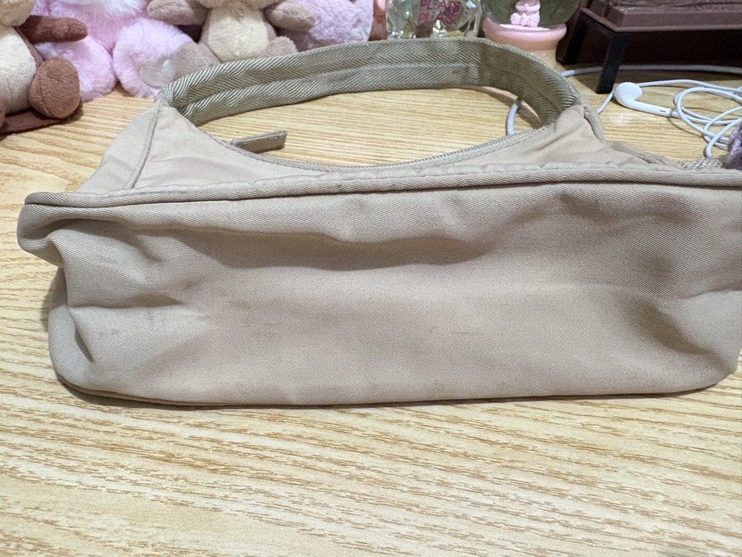 Authentic Vintage Prada Nylon Hobo Bag Not Re Edition (Category: Luxury Bags & Wallets) located in Manila. Submitted by ervy_ (Listing ID 1435549681, Image 3). Description: - Authentic Prada hobo bag - Beige nylon material - Top zipper closure - Fabric shoulder strap - Prada triangle logo with issue, no enamel - Well used.