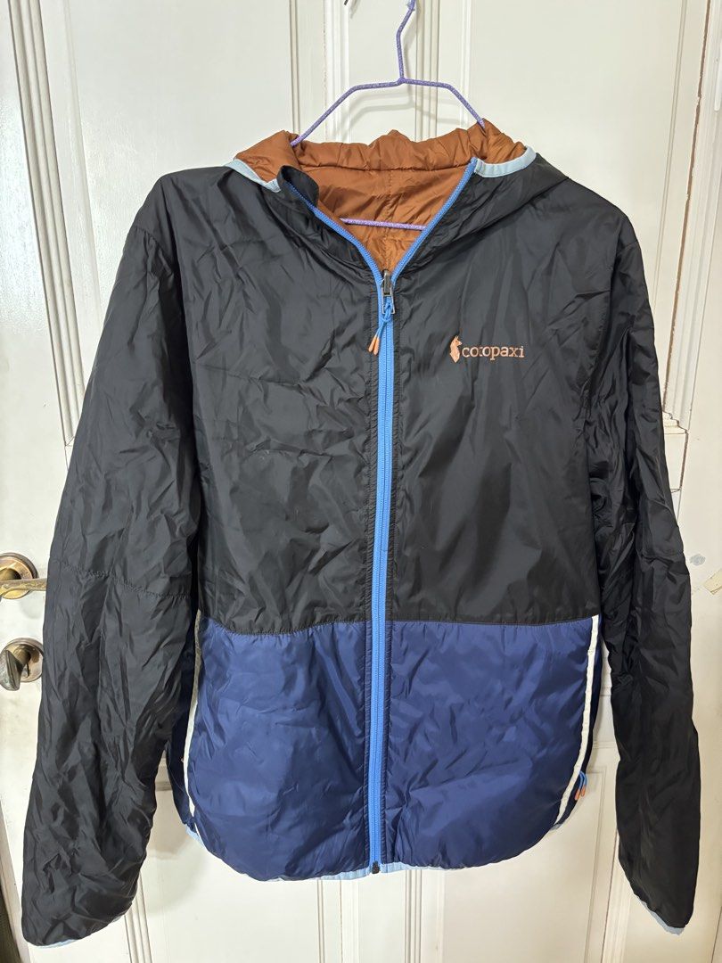 Cotopaxi Hooded Insulated Jacket (Category: Coats, Jackets and Outerwear) located in Singapore. Submitted by everesther (Listing ID 1435570063, Image 1). Description: - Cotopaxi Insulated Hooded jacket - Black and blue exterior, brown interior - Full zip closure - External and internal pockets on both sides, including zip pocket on inner left side .