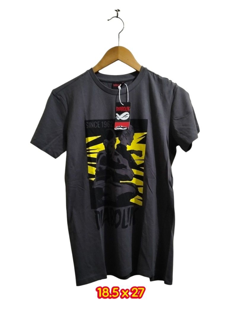 Diabolik since 1985 Graphic Tee (Category: Tshirts & Polo Shirts ) located in Manila. Submitted by badsaints (Listing ID 1435557336, Image 1). Description: - Dark gray Diabolik t-shirt - Features a graphic design with yellow accents - Crew neck and short sleeves - Size: 18.5 x 27 - Brand new with tag attached - Unworn condition.