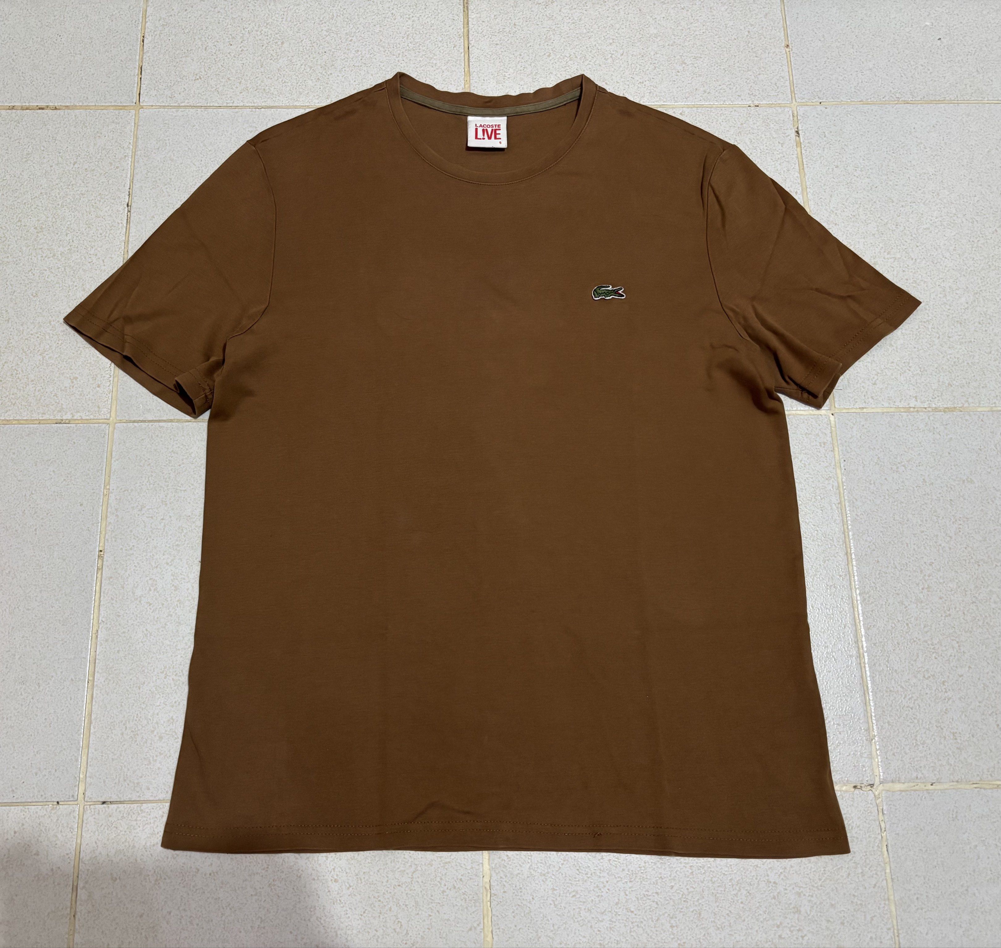 Lacoste Live Brown T-Shirt (Category: Tshirts & Polo Shirts ) located in Manila. Submitted by kenriegab (Listing ID 1435612825, Image 1). Description: - Lacoste Live T-shirt - Size 5 - Classic Lacoste logo on the chest - Comfortable crew neck - Short sleeves - Made from 100% cotton - Perfect for everyday wear Dimes: L 26.5 x W 19.5 Color rate: 9 / 10 Excellent condition +shipping fee.