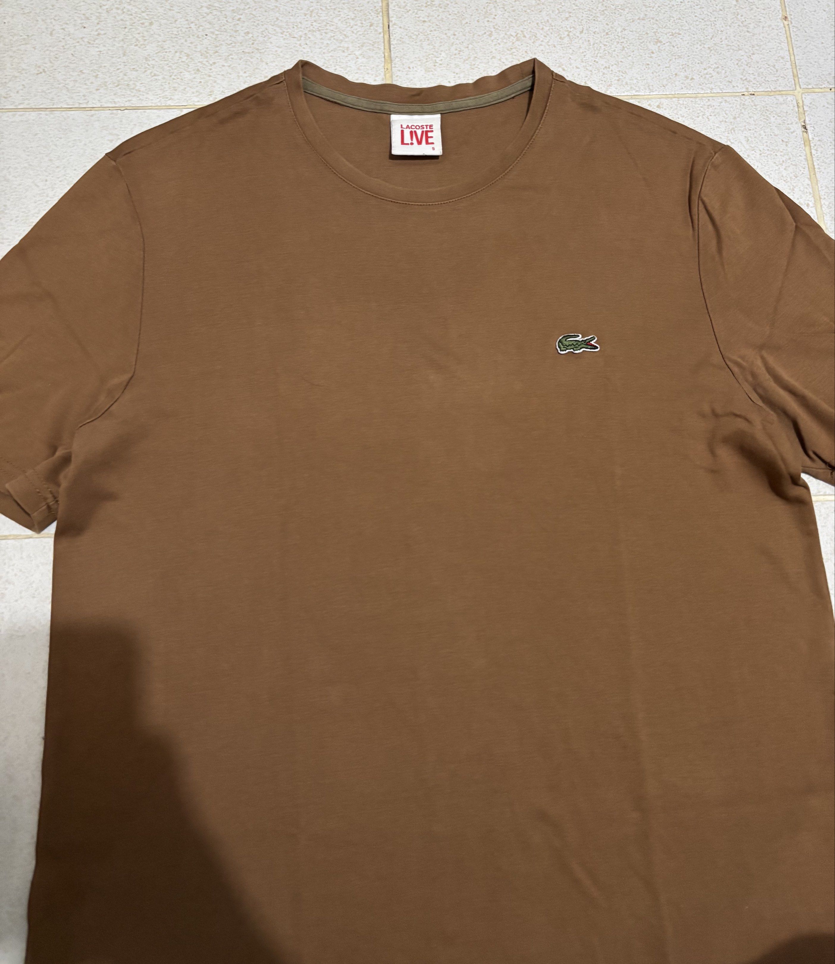 Lacoste Live Brown T-Shirt (Category: Tshirts & Polo Shirts ) located in Manila. Submitted by kenriegab (Listing ID 1435612825, Image 2). Description: - Lacoste Live T-shirt - Size 5 - Classic Lacoste logo on the chest - Comfortable crew neck - Short sleeves - Made from 100% cotton - Perfect for everyday wear Dimes: L 26.5 x W 19.5 Color rate: 9 / 10 Excellent condition +shipping fee.