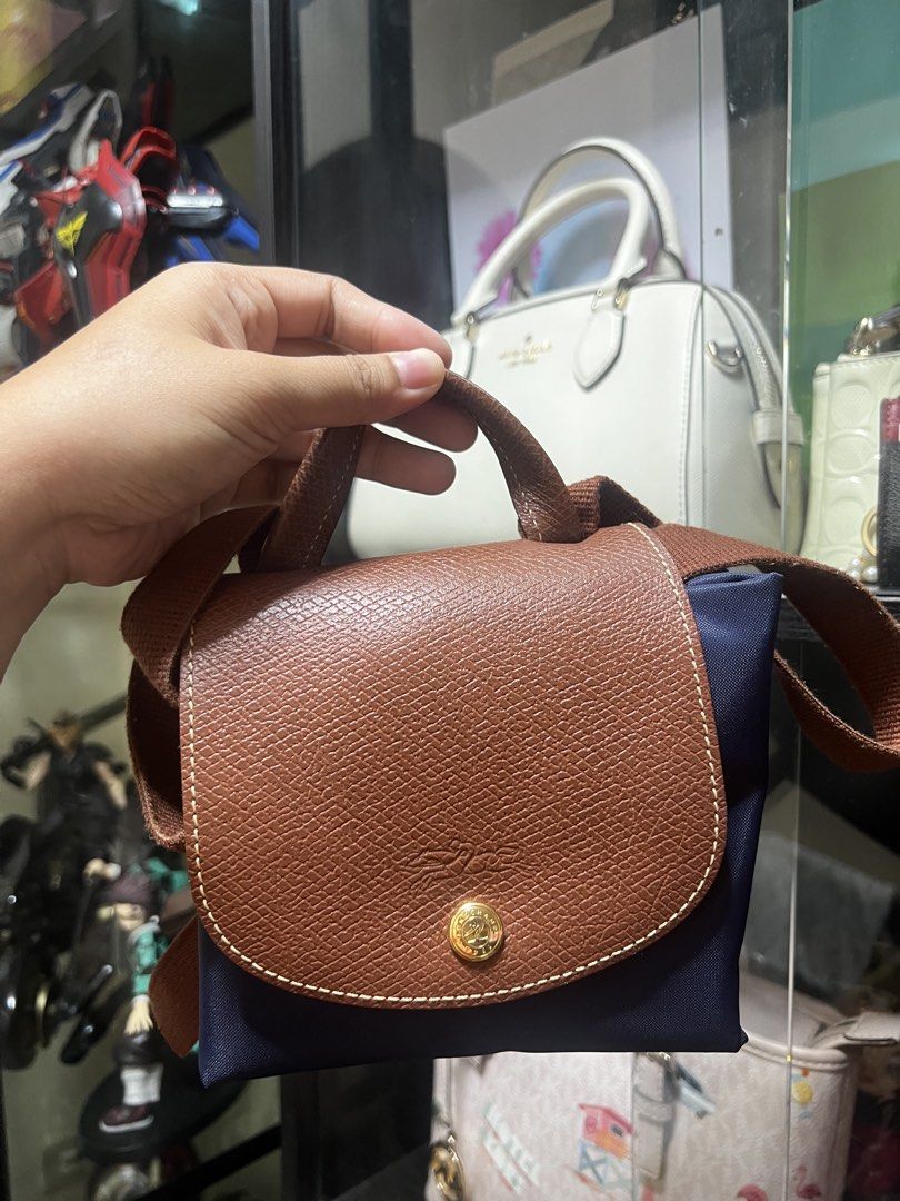 Longchamp Le Pliage Backpack (Category: Backpacks) located in Caloocan City. Submitted by ericavi_g (Listing ID 1435623547, Image 1). Description: - Longchamp Le Pliage backpack - Brown leather flap and handle - Navy blue body - Adjustable straps - Gold-colored button closure - Ideal for everyday use Orig selling low preloved.