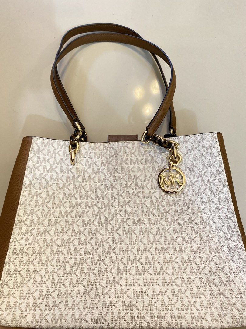 Michael Kors Tote Bag (Category: Luxury Bags & Wallets) located in Manila. Submitted by danjim (Listing ID 1435532526, Image 2). Description: - Authentic Michael Kors tote bag - Classic MK logo print - Brown leather handles and accents - Gold-tone chain detail - Includes MK logo charm - Medium size.