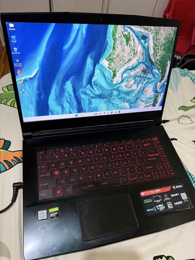 MSI GF63 Thin 9SC Gaming Laptop (Category: Laptops & Notebooks) located in Angono. Submitted by xxxallaboutbagsxxx (Listing ID 1435641082, Image 3). Description: - MSI GF63 Thin 9SC-090PH gaming laptop - Sleek black design with MSI logo - Red backlit keyboard - Powered by Intel Core i5 processor - Equipped with NVIDIA GeForce GTX 16 series graphics - Displays a game interface - Original Price: ₱69,895.00.