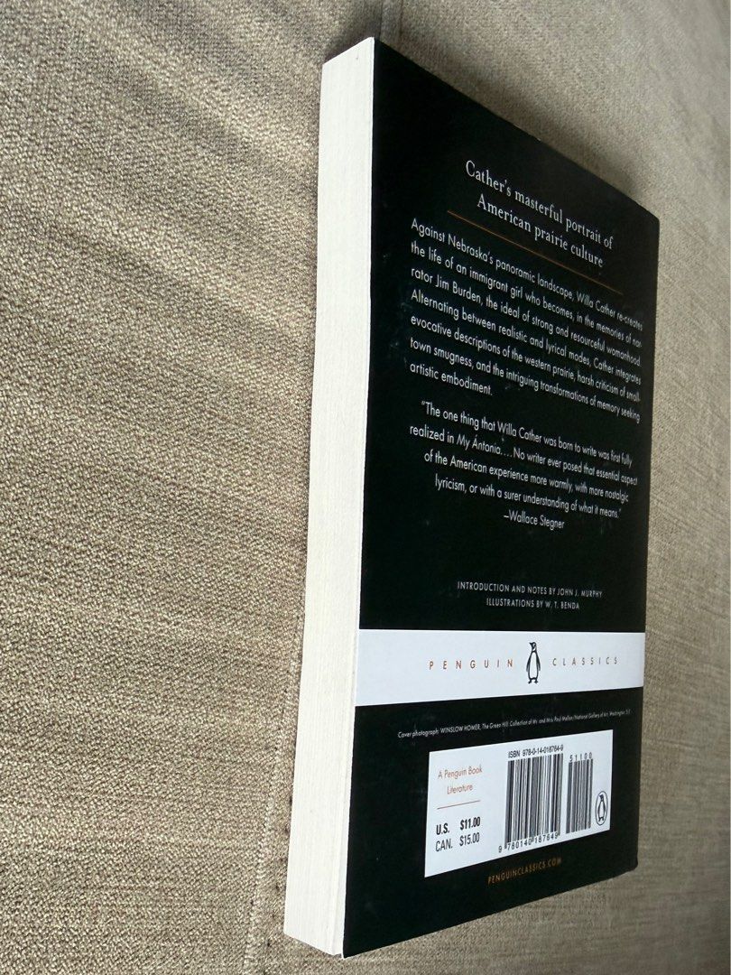 My Antonia - Willa Cather (Penguin Classics ) (Category: Storybooks) located in Davao. Submitted by friesflakes (Listing ID 1435524998, Image 3). Description: - "My Antonia" by Willa Cather - Penguin Classics edition - Cover illustration of a woman in a field - Includes story summary on the back - Features a quote by Wallace Stegner - White spine with Penguin Classics logo.