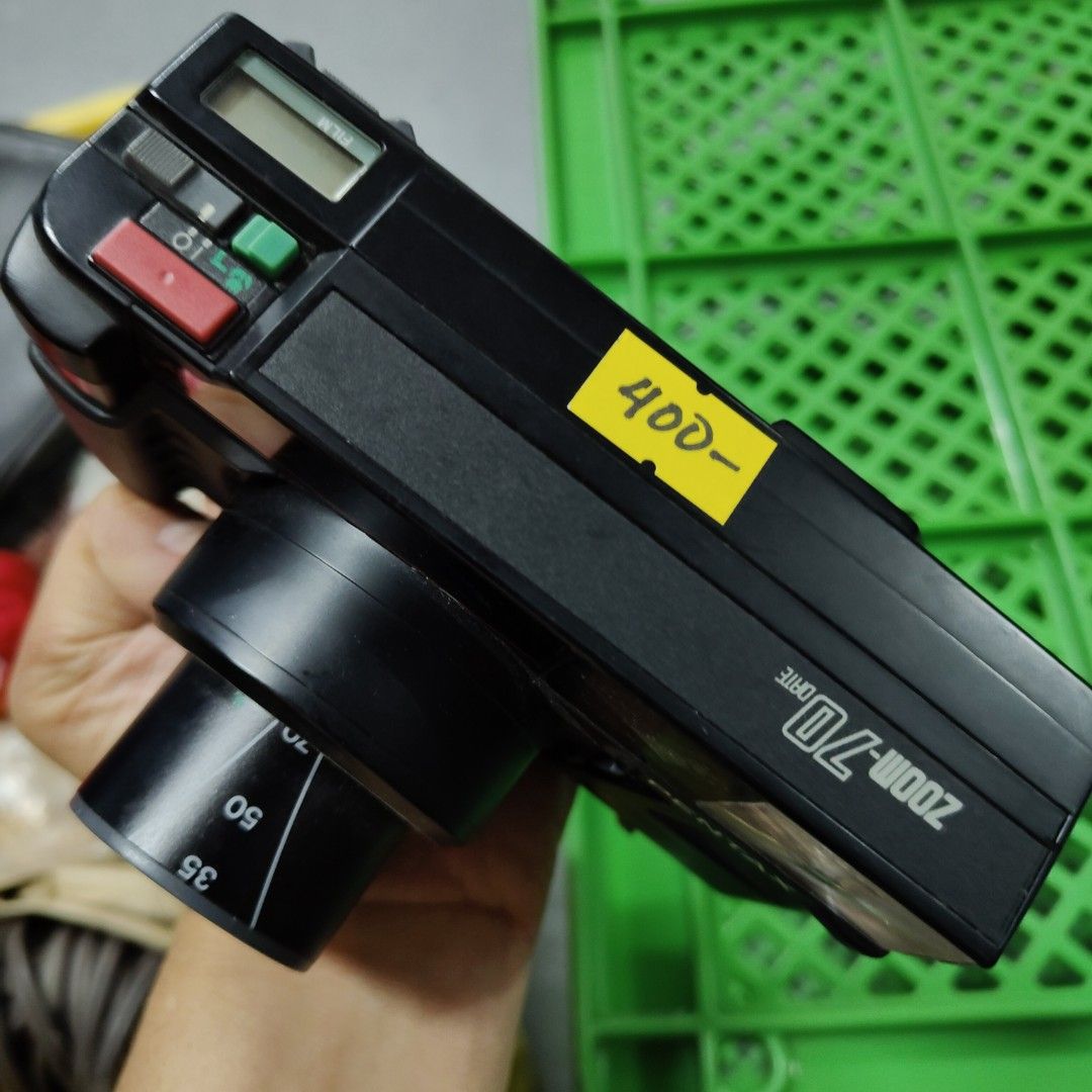 Pentax Zoom 70 Film Camera (Category: Cameras) located in Manila. Submitted by rossinicalabig (Listing ID 1435588606, Image 2). Description: 400 Pesos Only. UNTESTED WITH BATT & FILM. CONDITION: JUNK / FOR PARTS OUT/ EXPERIMENT. Pentax Zoom 70 film camera with a 35-70 zoom lens. Features a built-in flash and various control buttons. The camera has a lens with macro capabilities. The price tag shows 400. Requires four AAA batteries to operate. Che