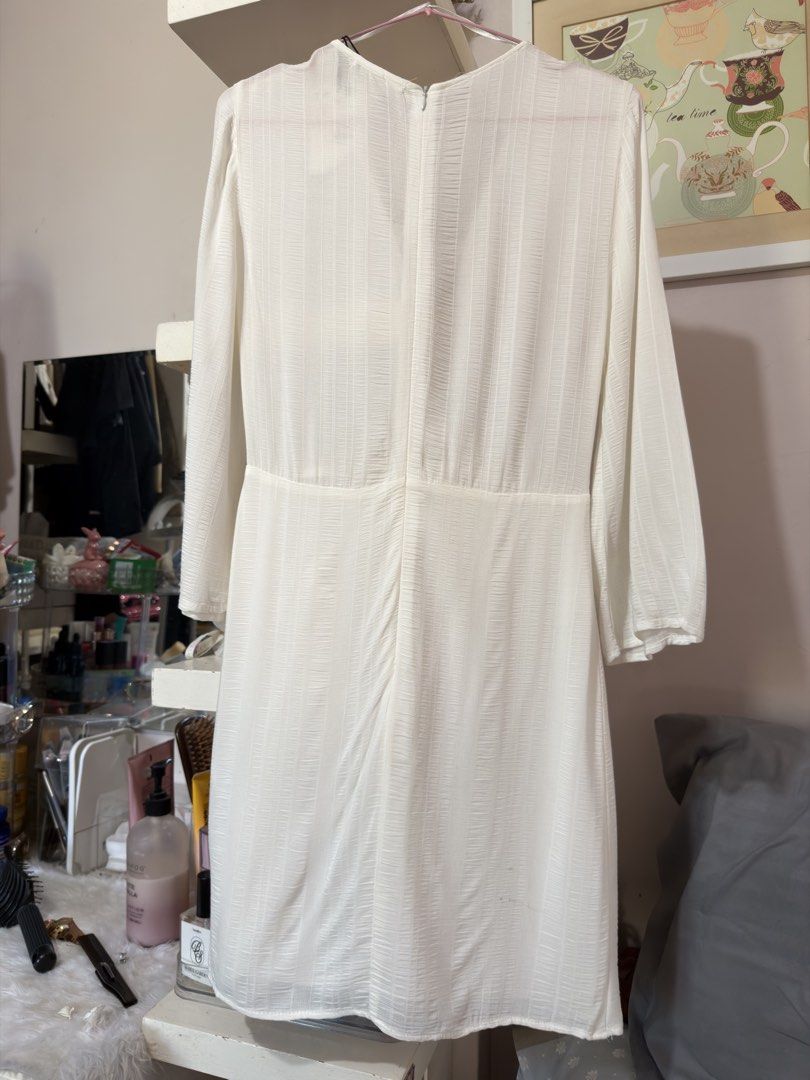 Pull & Bear White Wrap Dress (Category: Dresses) located in Apalit. Submitted by ic_declutter (Listing ID 1435596027, Image 3). Description: White wrap dress from Pull & Bear. Features a V-neckline and long sleeves. The dress has a tie detail at the waist and a flowing skirt. Made in Morocco. Size S/USA S/MEX 26..