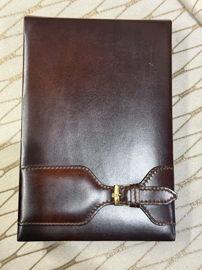Rolex Leather Notebook (Category: Luxury Bags & Wallets) located in Pasay City. Submitted by alphaq21 (Listing ID 1435547932, Image 1). Description: Leather notebook from Rolex. It features a brown leather exterior with a buckle closure. The interior includes a notepad with the Rolex logo. The back of the notebook has the Rolex logo and the text "MONTRES ROLEX S.A. - GENEVE SUISSE - 71.06.04". Vintage Rolex Dealer’s Quote Leather Notepad Notebook