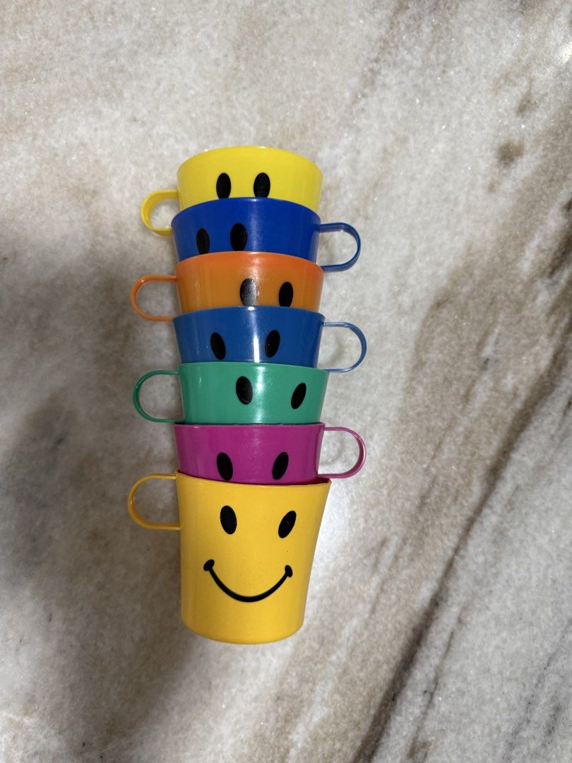 Smiley Face Stackable Cups (Category: Coffee & Tea Tableware) located in Kuala Lumpur. Submitted by mamaCKMM (Listing ID 1435639178, Image 1). Description: - Set of 5 stackable cups - Colors: Yellow, blue, orange, green, and purple - Each cup features a smiley face - Includes a handle on each cup - Perfect for kids or kitchen use Condition: 8/10.