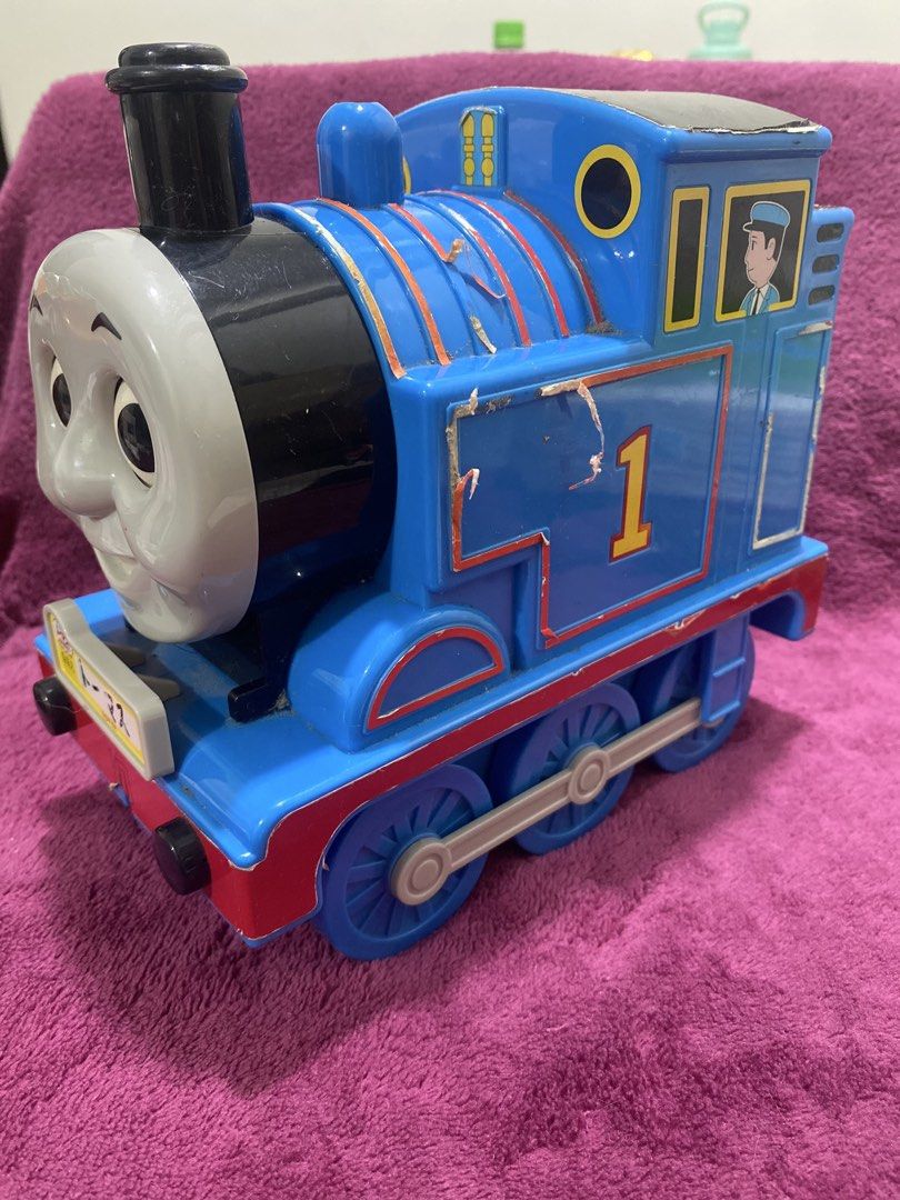 Thomas the Tank Engine Toy Lotte Candy Canister (Category: Vehicle & Diecast Models) located in Quezon City. Submitted by declutterthingzzz (Listing ID 1435713374, Image 2). Description: - Thomas the Tank Engine toy - Blue with the number 1 - Smiling face and conductor detail - Visible wheels Lotte Candy Holder.