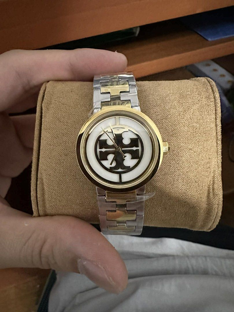 Tory Burch Watch (Category: Women's Watches) located in Quezon City. Submitted by raymonet (Listing ID 1435574626, Image 2). Description: - Tory Burch watch - Gold-tone bezel - Two-tone stainless steel band - Tory Burch logo on watch face - Includes original box and shopping bag - Perfect for any occasion.