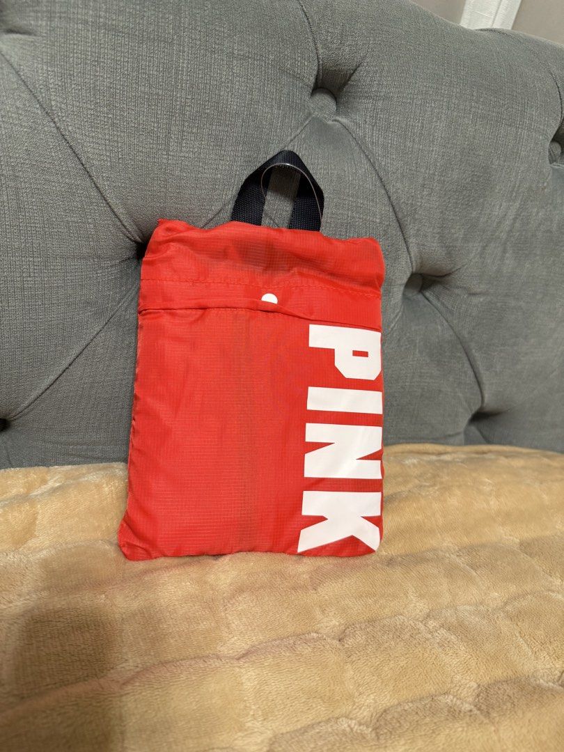 Victoria's Secret PINK Packable Duffel Bag (Category: Tote Bags) located in Angeles City. Submitted by ushoppes (Listing ID 1435528359, Image 2). Description: Victoria's Secret PINK packable duffel bag. It is red with the PINK logo printed on it. The bag can be folded into a compact size for easy storage. It has black handles and a zipper closure. The bag is new and comes with its original tag bought in the USA..