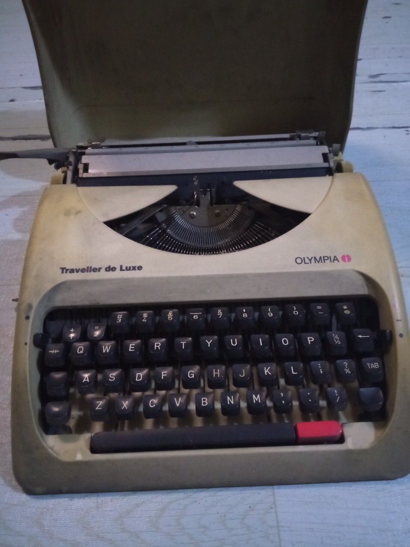 Vintage Olympia Traveller de Luxe Typewriter (Category: Stationery & School Supplies) located in Manila. Submitted by aosram (Listing ID 1435647451, Image 2). Description: Olympia Traveller de Luxe typewriter with original case. Full keyboard, black keys, red space bar, and cream body. Includes carrying case. issue:no ink.