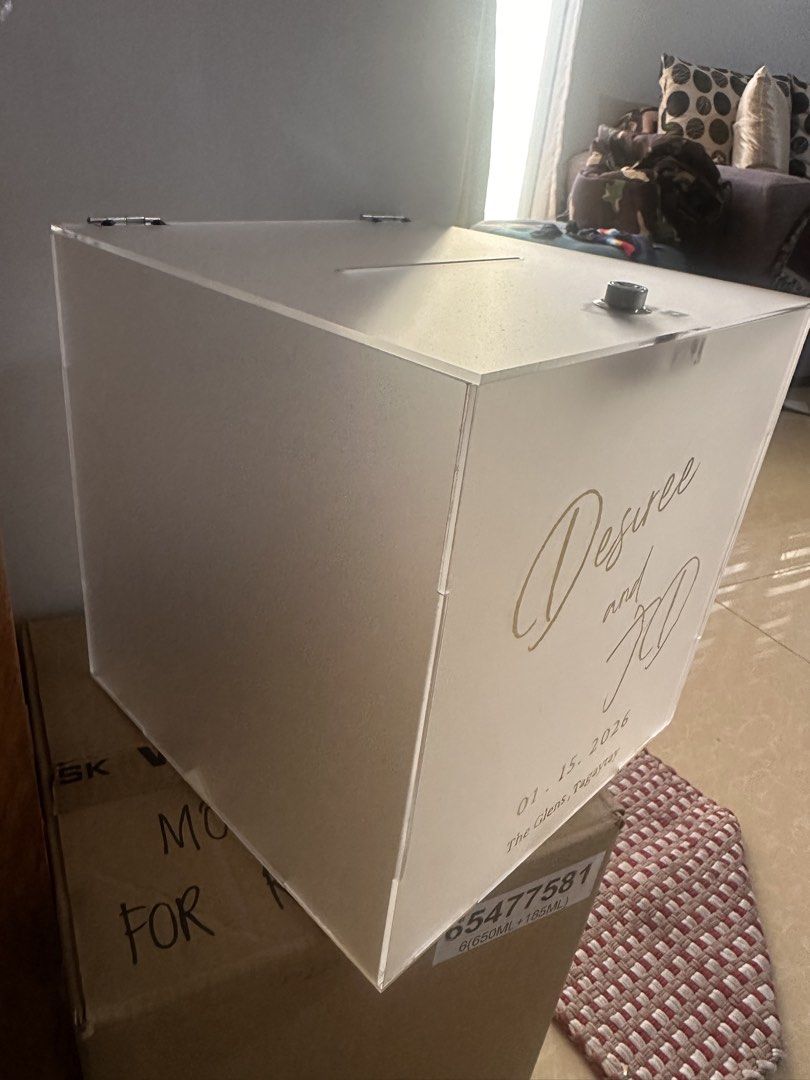 Acrylic Box with Lock used once for wedding (Category: Storage Boxes & Baskets) located in Manila. Submitted by cosmichorse_d0ad24 (Listing ID 1438880875, Image 2). Description: - Acrylic donation box - Frosted finish - Features a slot and secure lock - Personalized with: 'Desiree and KD','01.15.2026', and 'The Glass Tower, Tagaytay' (EASY TO REMOVE) - Ideal for various events.