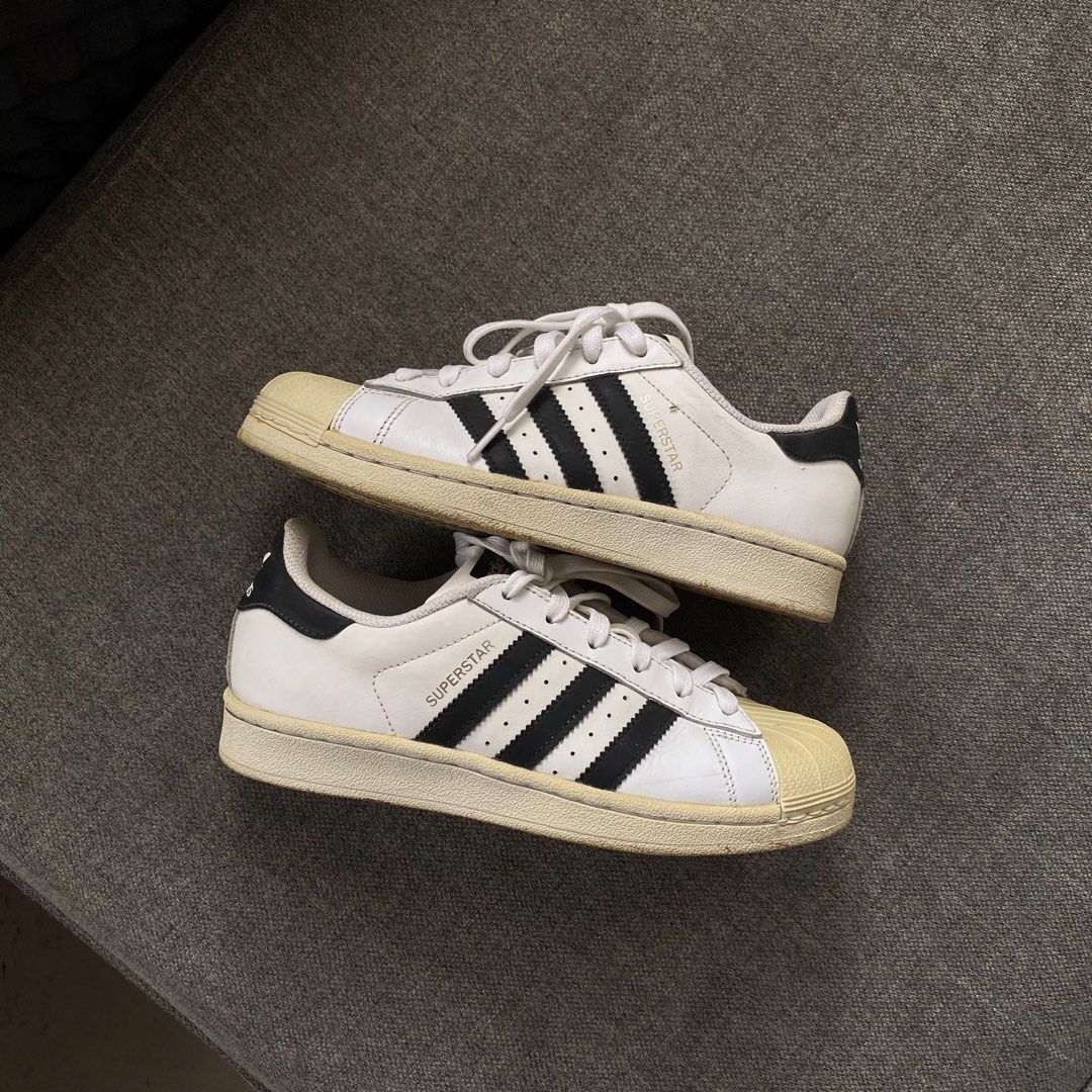 Adidas Superstar White Black Sneakers (Category: Sneakers) located in Tagum. Submitted by staysultry (Listing ID 1438966161, Image 1). Description: - Adidas Superstar sneakers - White with black stripes - Iconic shell toe design - White laces - Adidas logo on heel - Soles show wear - Adidas logo on insoles.