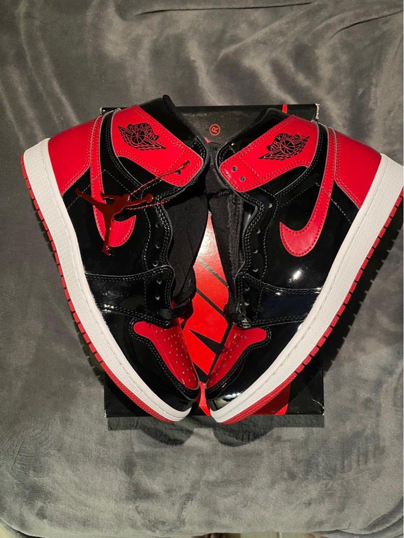 Air Jordan 1 Patent Bred (Category: Sneakers) located in Pasig City. Submitted by clairedaniellett (Listing ID 1438925018, Image 1). Description: - Air Jordan 1 Patent Bred sneakers - Black and red colorway - Patent leather finish - Nike swoosh and Air Jordan logo - Comes with original box - White midsole, red outsole.