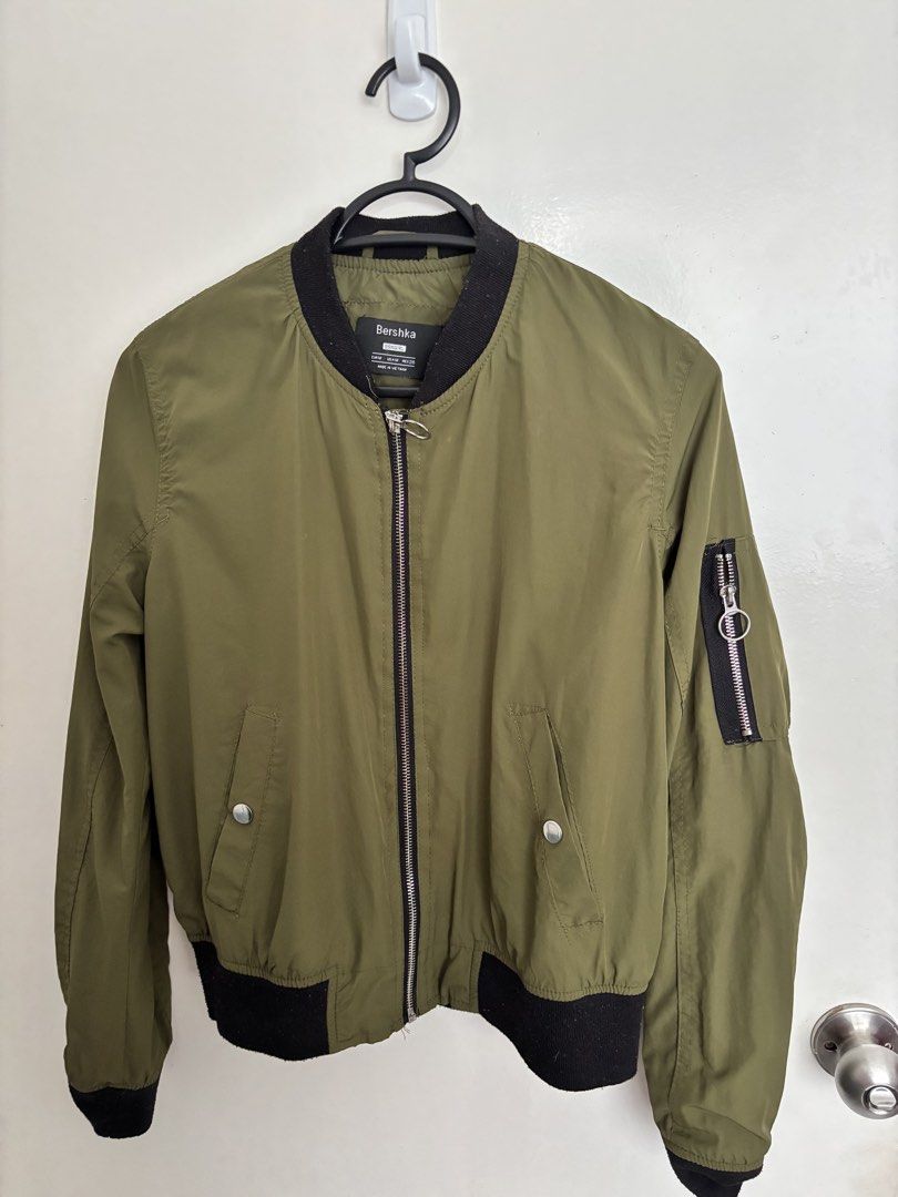 Bershka Bomber Jacket Medium (Category: Coats, Jackets and Outerwear) located in Taguig. Submitted by macs_stuff (Listing ID 1438999963, Image 1). Description: - Bershka olive green bomber jacket - Black collar, cuffs, and hem - Zipper closure - Two front pockets with snap closures - Zippered pocket on left sleeve Rfs: decluterring.