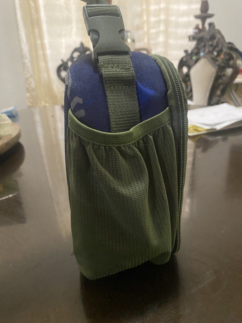 BUNDLE Dinosaur Lunch Bag with Fidget Toys (Category: Other Babies Going Out Needs) located in Marikina City. Submitted by sansa16 (Listing ID 1438897787, Image 3). Description: - Dinosaur-themed lunch bag: - Blue exterior with dinosaur prints - Green strap - Side pocket - Zipper closure - Fidget Toys: - Rainbow square pop-it - Pizza slice fidget toy - Heart fidget toy - Dinosaur pop-it - Colorful chain fidget toy.