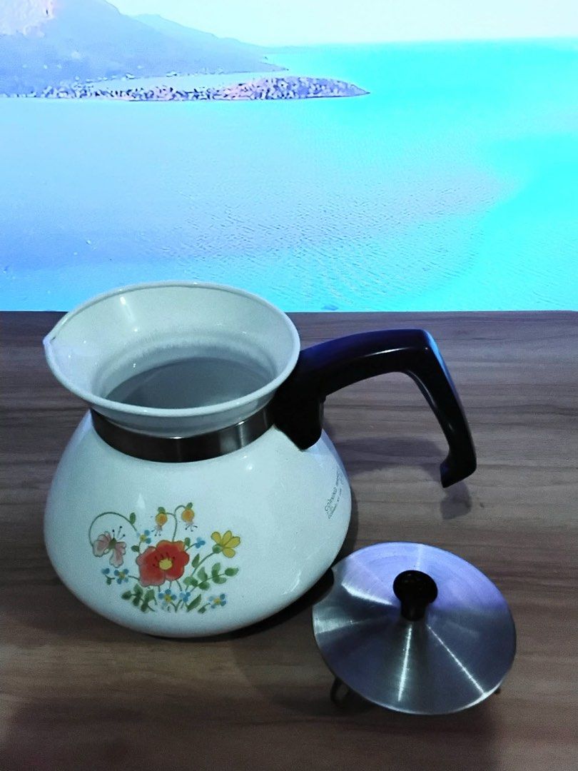 Vintage Corningware Floral Tea Pot (6Cups) (Category: Coffee & Tea Tableware) located in Quezon City. Submitted by unique_vintage_shop (Listing ID 1438897622, Image 3). Description: P1300 This is a vintage Corning Ware P-104 6-cup teapot/kettle featuring the “Wildflower” pattern. Pattern: The “Wildflower” design, introduced in the 1970s, features orange, yellow, and blue flowers with a butterfly. Material: The pot is made of Corning Ware’s durabl
