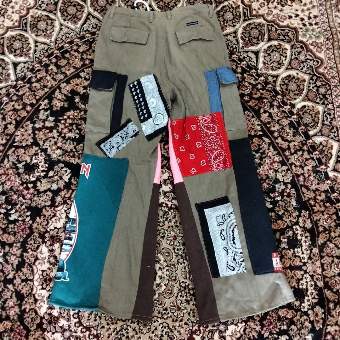 Custom Patchwork Cargo Pants (Category: Trousers) located in Besut. Submitted by fiercedog_72f048 (Listing ID 1439010115, Image 2). Description: - Custom-made cargo pants - Olive green base color - Unique patchwork design - Features patches from Slipknot and Iron Maiden band t-shirts, and red bandanas - Drawstring waist - Multiple pockets - One-of-a-kind design.