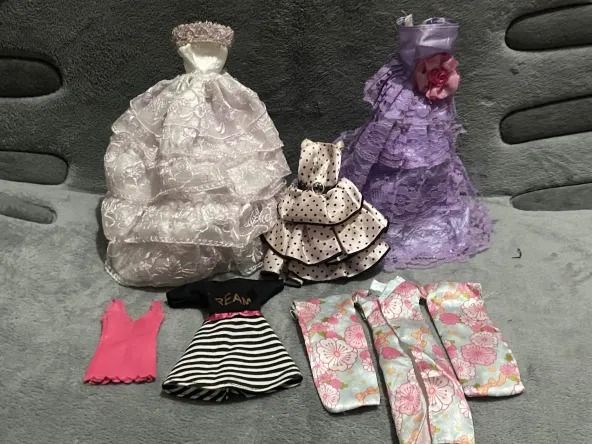 Doll Clothes Set - Dresses and Accessories Take all bundle set as is (Category: Babies & Kids Fashion) located in Valenzuela. Submitted by feur.u (Listing ID 1439019639, Image 2). Description: - Doll clothes set for dolls. - Includes: - Two long dresses (white and purple). - Polka dot dress. - Black and white striped dress. - Pink top. - Floral kimono-style accessory. - Variety of styles for doll play..