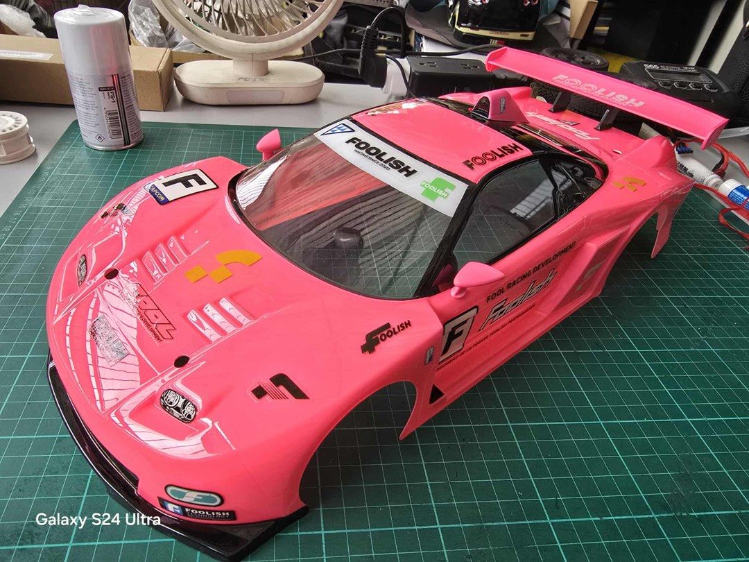 Foolish Racing RC Car Body for 1/10 scale (Category: Vehicle & Diecast Models) located in Quezon City. Submitted by notsrcph (Listing ID 1438984327, Image 1). Description: - Pink RC car body - Foolish Racing decals - Includes decals for Fool Racing Development and Capcom - Features a large rear wing - Detailed graphics - Sleek design with clear windshield and side vents - Designed for RC car use - 190mm .
