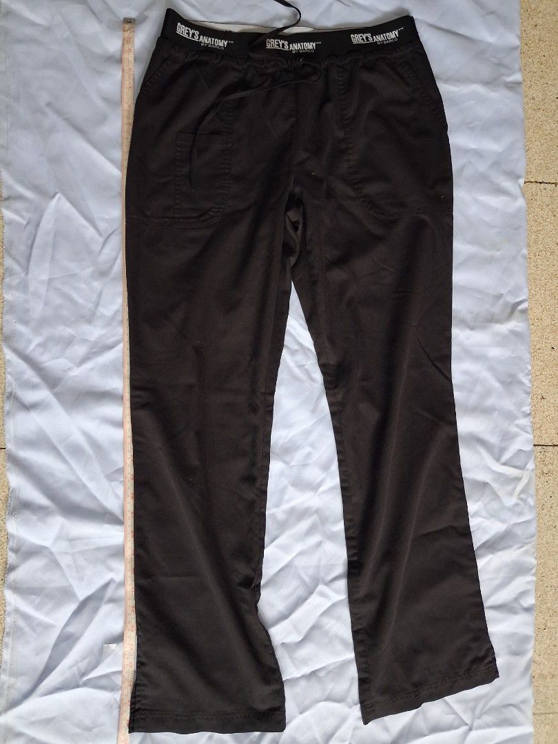 Grey's Anatomy Black Scrub Pants (Category: Other Bottoms) located in Manila. Submitted by beardedbot (Listing ID 1438914475, Image 1). Description: Black scrub pants from Grey's Anatomy. Features a drawstring waist. The pants appear to be made of a durable fabric. The pants are laid flat on a light blue surface. The Grey's Anatomy logo is visible on the waistband..