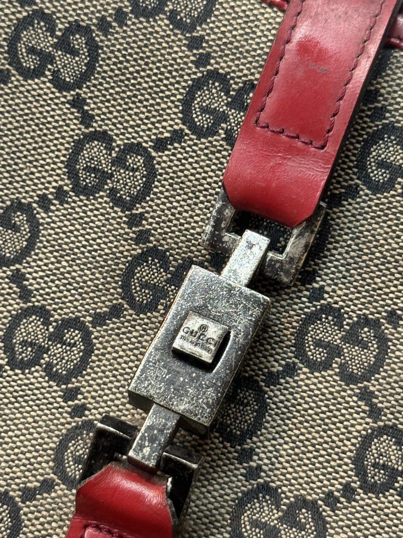 Gucci Handbag with Red Accents (Category: Luxury Bags & Wallets) located in Manila. Submitted by keantuttt (Listing ID 1438971004, Image 2). Description: - Gucci handbag - Iconic GG monogram pattern - Red leather straps and trim - Silver-tone buckle closure - 'Made in Italy' tag - Black fabric interior - Unique bag shape.