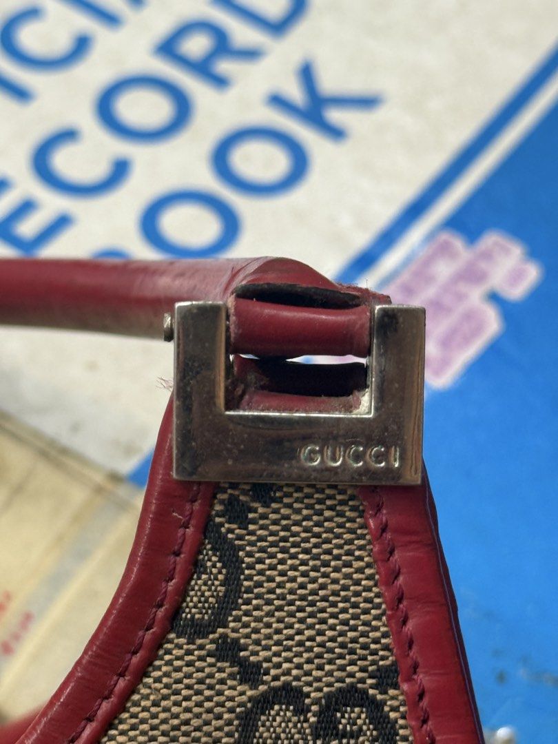 Gucci Handbag with Red Accents (Category: Luxury Bags & Wallets) located in Manila. Submitted by keantuttt (Listing ID 1438971004, Image 3). Description: - Gucci handbag - Iconic GG monogram pattern - Red leather straps and trim - Silver-tone buckle closure - 'Made in Italy' tag - Black fabric interior - Unique bag shape.