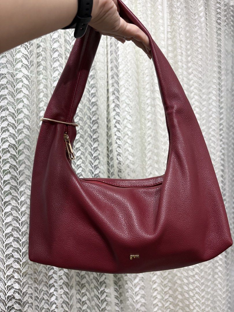 GVN Hobo Bag - Burgundy small size (Category: Shoulder Bags) located in Mandaue City. Submitted by denden22222 (Listing ID 1438973433, Image 1). Description: - Burgundy hobo bag by GVN - Single shoulder strap - Gold-toned zipper - Gold-toned metal accent - Pebbled texture - Minor wear and tear near the zipper.