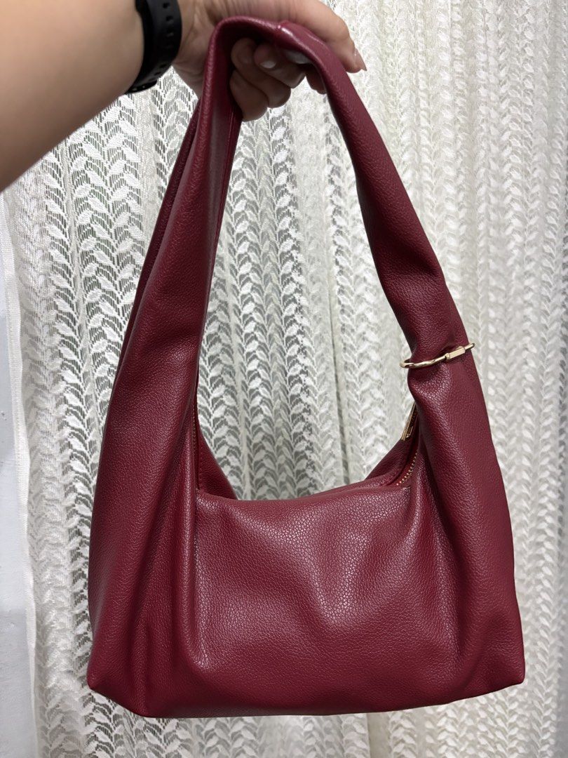 GVN Hobo Bag - Burgundy small size (Category: Shoulder Bags) located in Mandaue City. Submitted by denden22222 (Listing ID 1438973433, Image 2). Description: - Burgundy hobo bag by GVN - Single shoulder strap - Gold-toned zipper - Gold-toned metal accent - Pebbled texture - Minor wear and tear near the zipper.