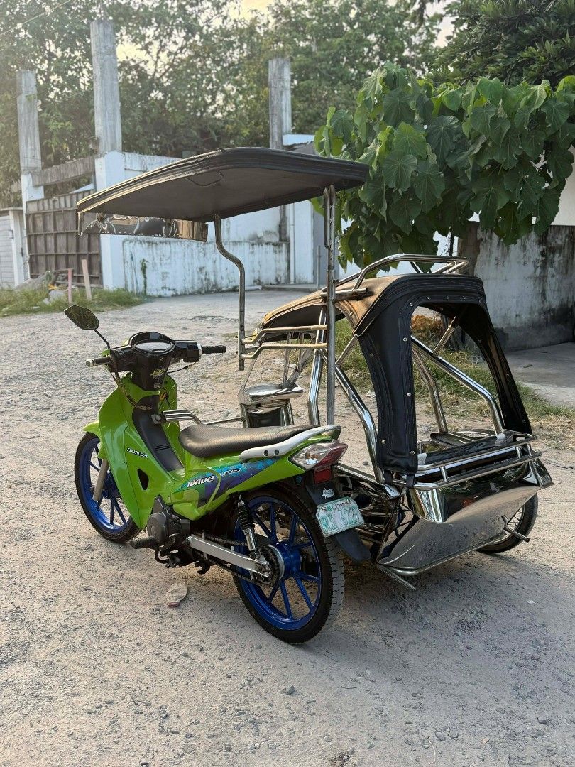 Honda Wave 125 Motorcycle with Sidecar (Category: Motorbikes for Sale) located in Balanga. Submitted by bravereender (Listing ID 1438898885, Image 3). Description: FOR SALE: Honda Wave 125 (2005) w/ Sidecar ✅ Complete Legal Papers ✅ Stock Engine ✅ 1st Owner (Acquired Unit) ✅ Tulisan Setup ✅ Volvo Stainless Sidecar 🤙 ✅ Daytona Mags ✅ Bago ang mga Gulong ✅ Tipid sa Gas 👌 📍 Location: San Jose, Balanga City, Bataan 📞 Contact: 0946 133 5509.