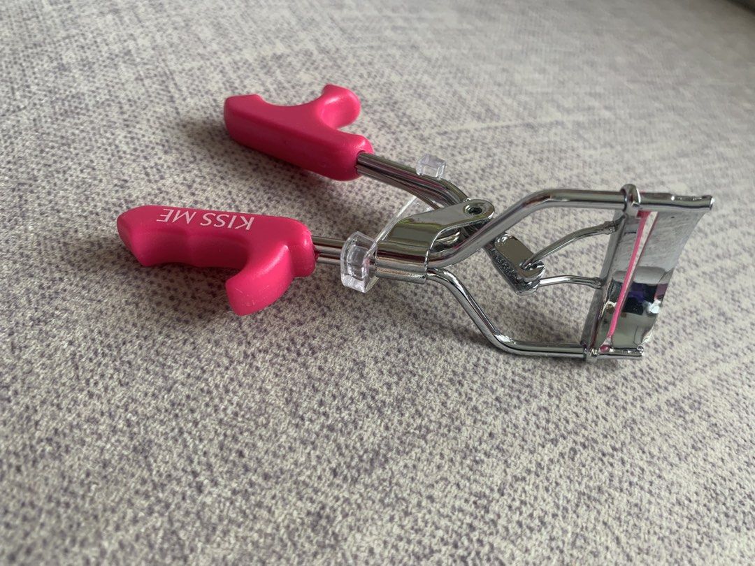 Hot pink Kiss Me eyelash curler (Category: Makeup) located in Singapore. Submitted by buysellcloset (Listing ID 1438945923, Image 2). Description: Kiss Me eyelash curler with bright pink handles and a silver metal frame Brand new .