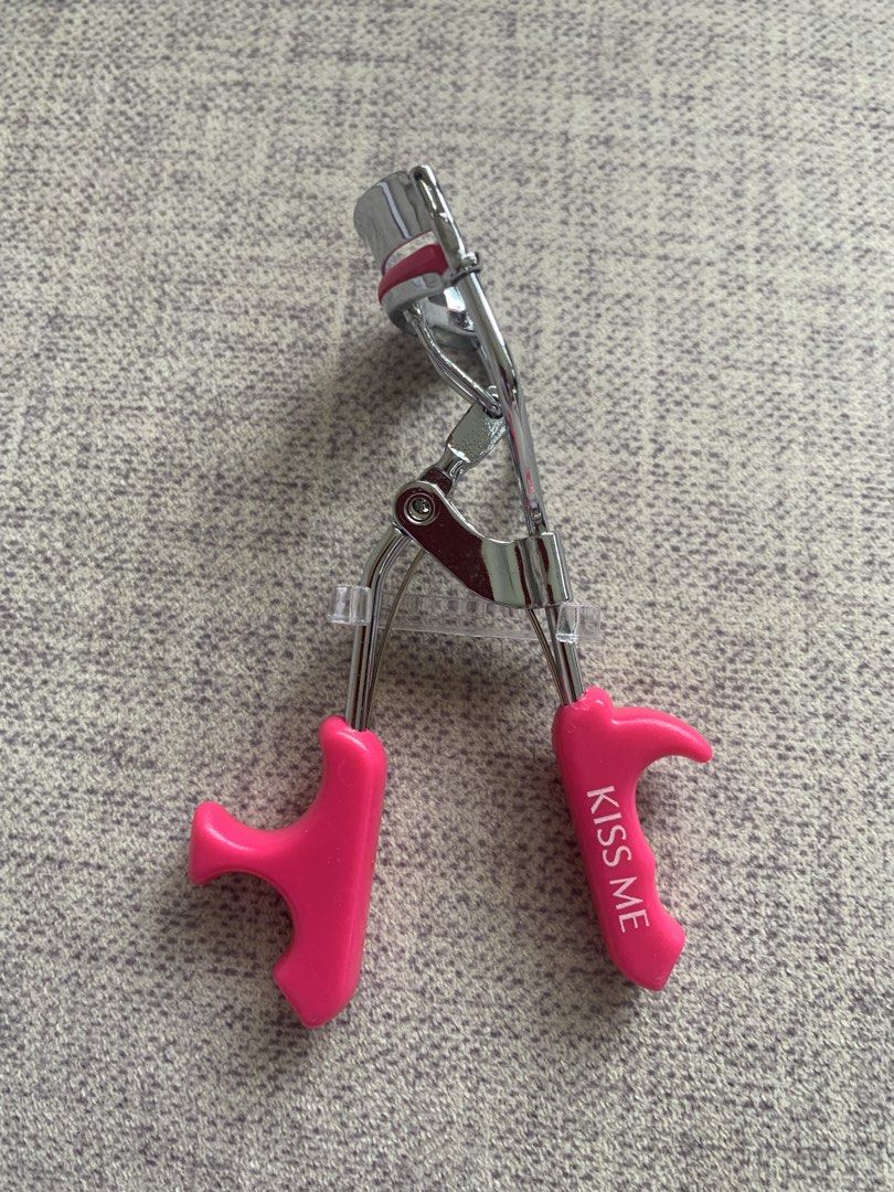 Hot pink Kiss Me eyelash curler (Category: Makeup) located in Singapore. Submitted by buysellcloset (Listing ID 1438945923, Image 1). Description: Kiss Me eyelash curler with bright pink handles and a silver metal frame Brand new .