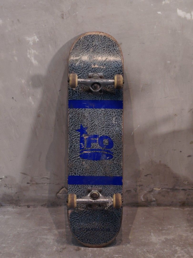 IFO Skateboard (Category: Skates, Rollerblades & Scooters) located in Valenzuela. Submitted by upcycle_things (Listing ID 1438960677, Image 1). Description: - IFO skateboard with a blue and grey design. - Textured grip tape for better control. - Features visible trucks and wheels. - IFO logo displayed on trucks and deck bottom. - Includes a blue stripe design..